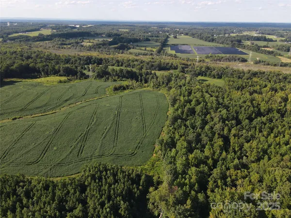 an aerial view of a residential houses with outdoor space and trees