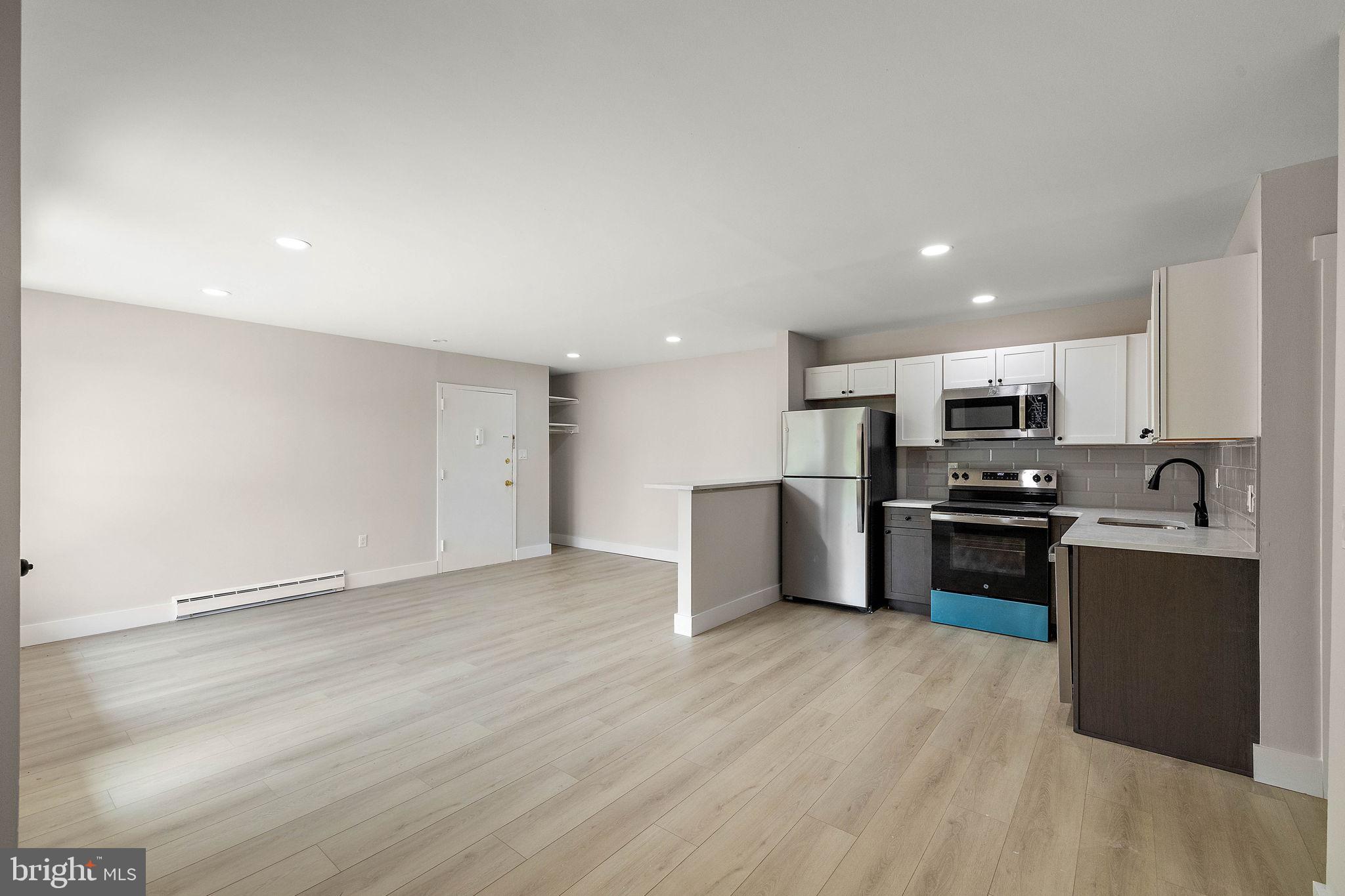 200 Brandywine Boulevard, Unit C7 Wilmington, DE 19803 - Photo 5 of 16 a kitchen with stainless steel appliances kitchen island granite countertop a stove top oven a sink and a refrigerator