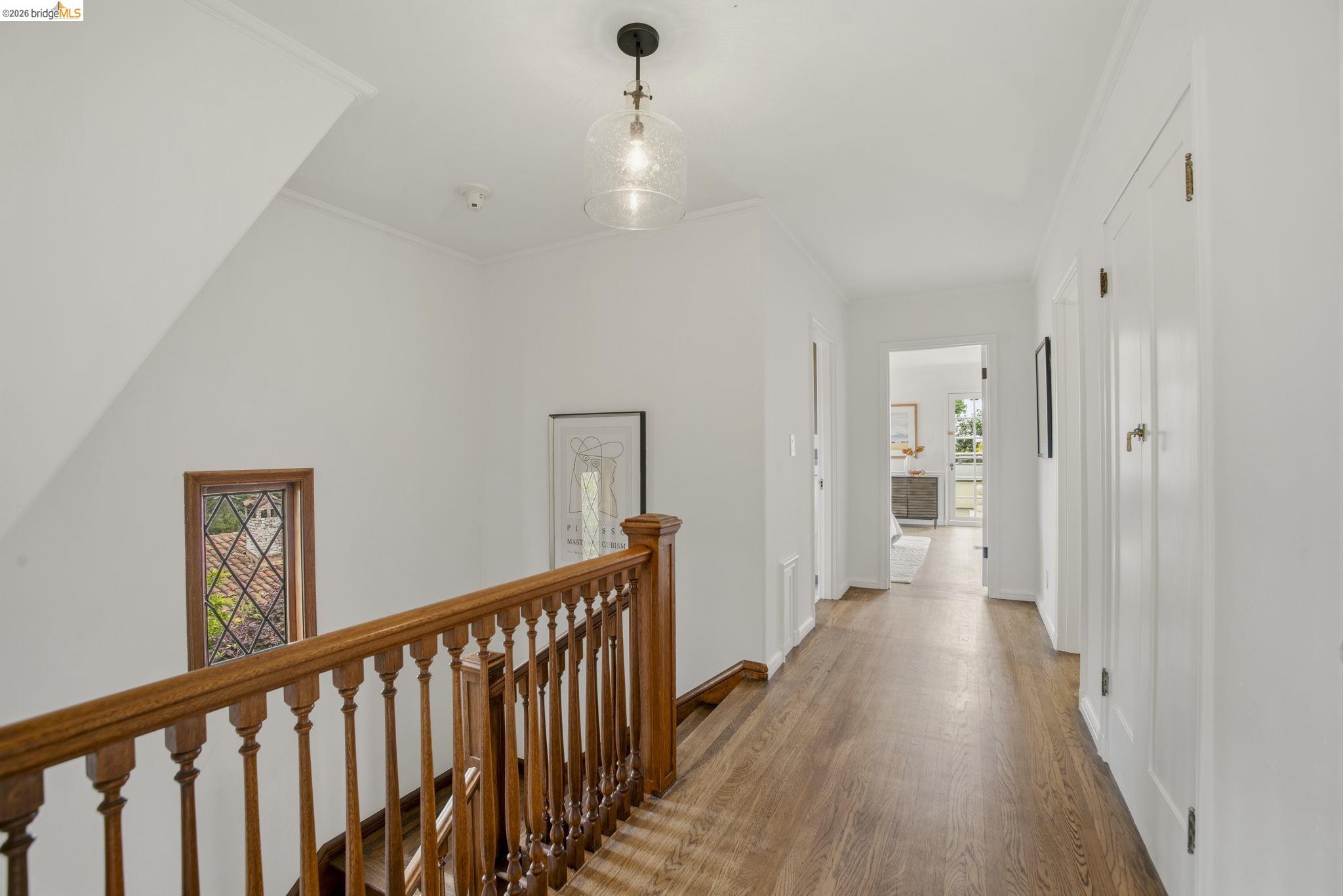 1087 Hubert Road Oakland, CA 94610 - Photo 19 of 67 Hallway featuring wood-finish flooring, white walls, and a decorative pendant light fixture