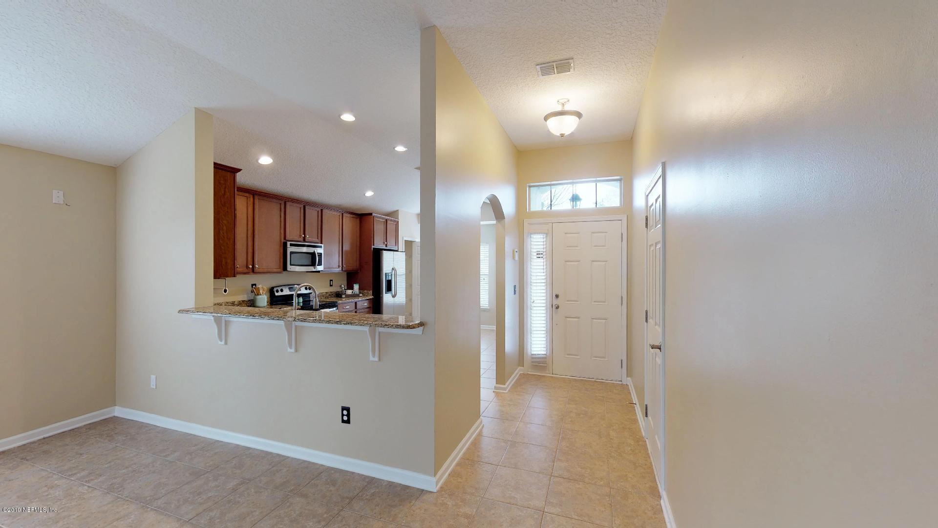 1919 Derringer Road Jacksonville, FL 32225 - Photo 14 of 42 a view of a kitchen with kitchen island a sink wooden floor and a refrigerator