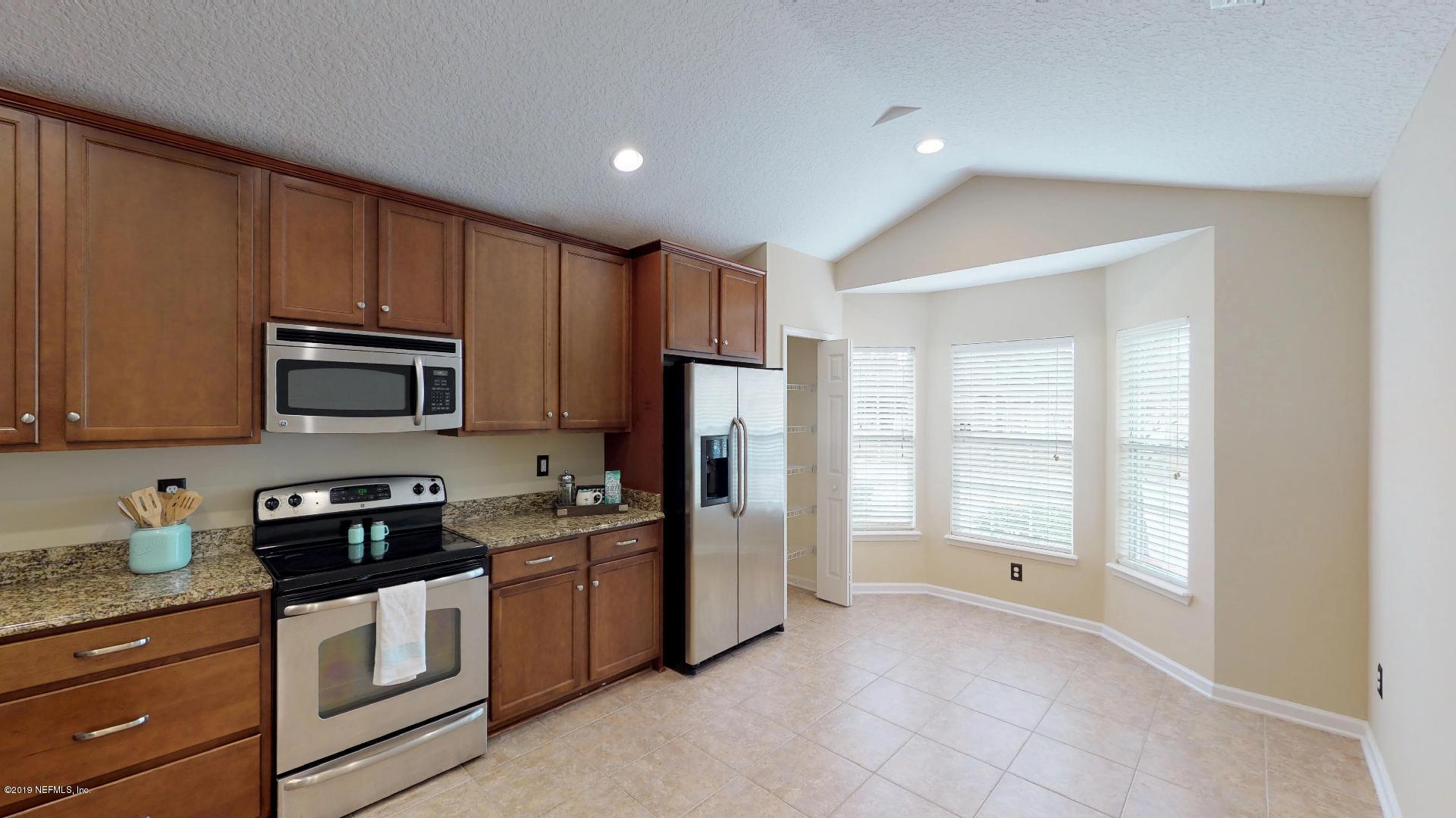 1919 Derringer Road Jacksonville, FL 32225 - Photo 7 of 42 a kitchen with granite countertop a refrigerator stove and microwave