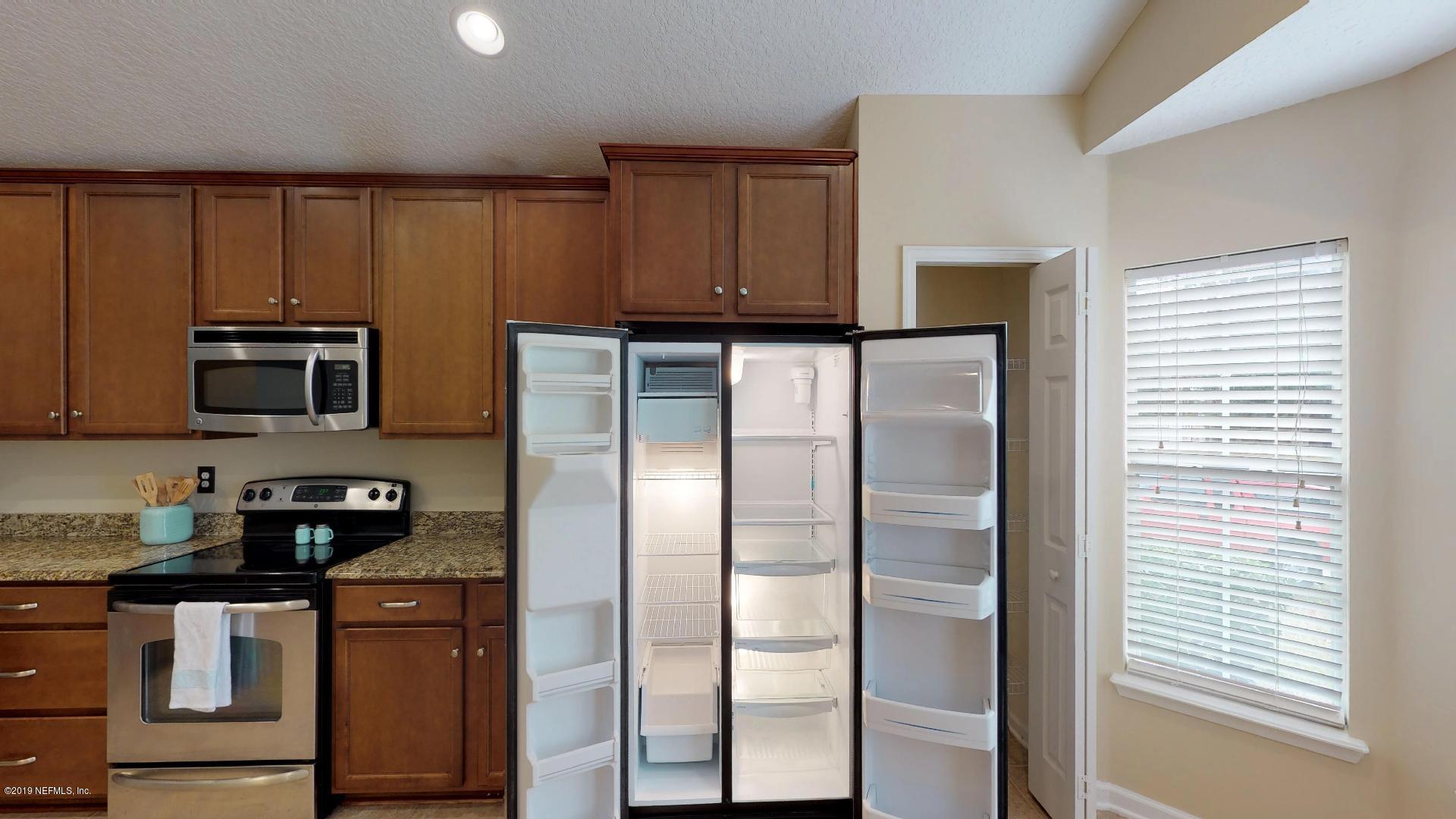 1919 Derringer Road Jacksonville, FL 32225 - Photo 8 of 42 a kitchen with stainless steel appliances granite countertop a refrigerator a stove and a sink with wooden floor