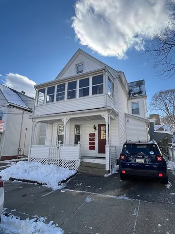 a car parked in front of a white house