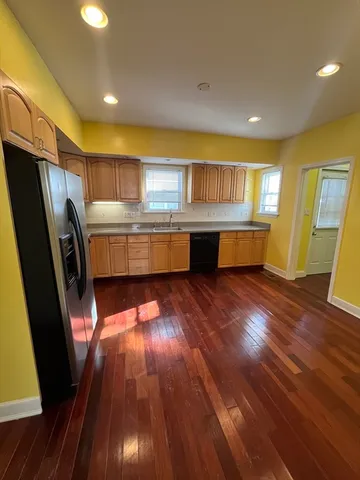 a kitchen with stainless steel appliances granite countertop a sink a stove wooden floor and cabinets