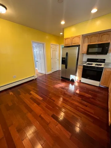 a view of kitchen with wooden floor and electronic appliances