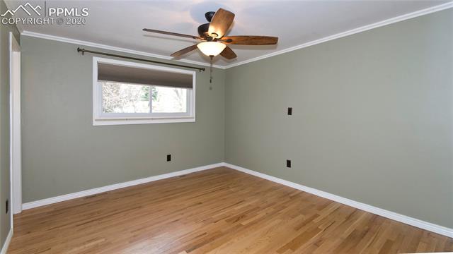 4027 Maxwell Road Colorado Springs, CO 80909 - Photo 25 of 35 Upper master bedroom, ceiling fan and great wood floors.