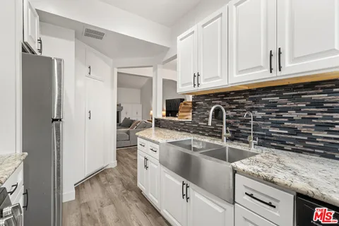 a kitchen with granite countertop a sink stove and refrigerator