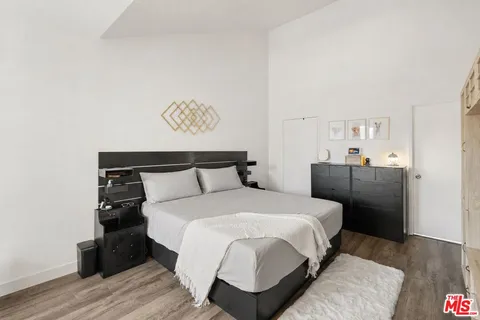 a bedroom with a bed and wooden floor