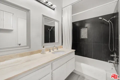 a bathroom with a tub sink and mirror