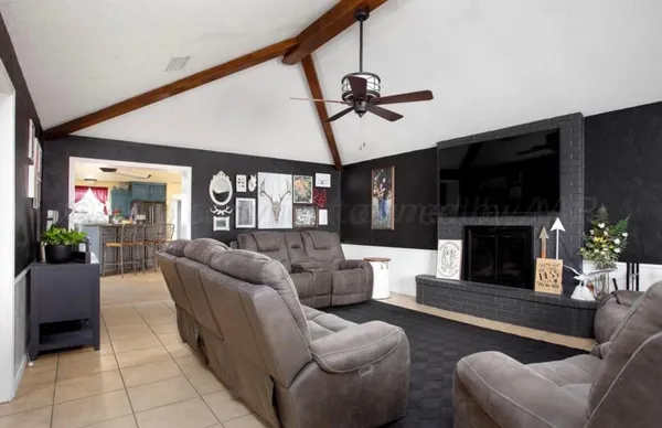 a living room with furniture a ceiling fan and a window