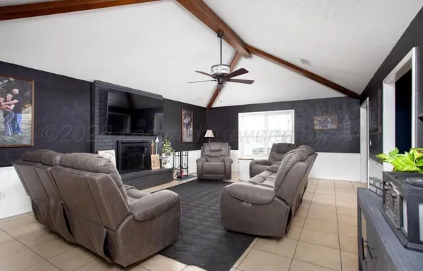 a living room with a flat screen tv a fireplace and a potted plant