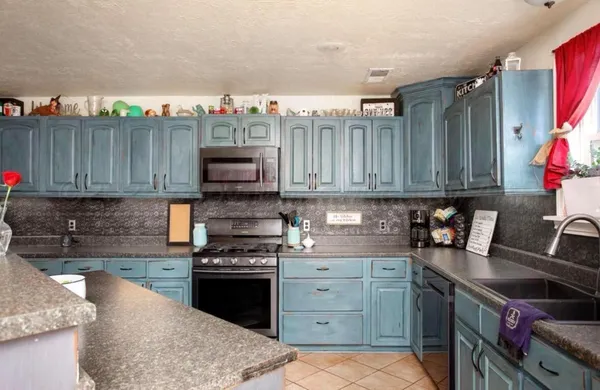 a kitchen with stainless steel appliances granite countertop a stove and a microwave