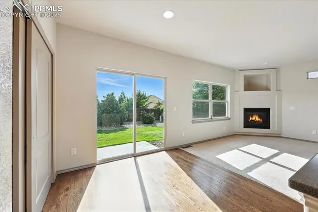 a view of an empty room with glass door and windows