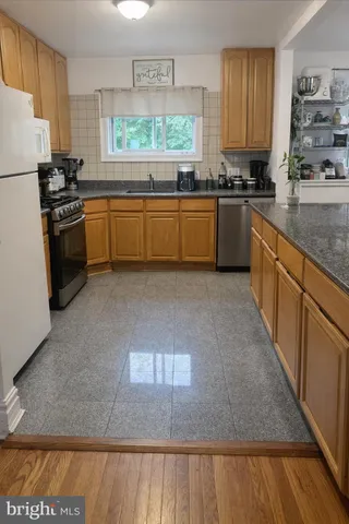 a kitchen with stainless steel appliances granite countertop a stove a sink dishwasher and a refrigerator