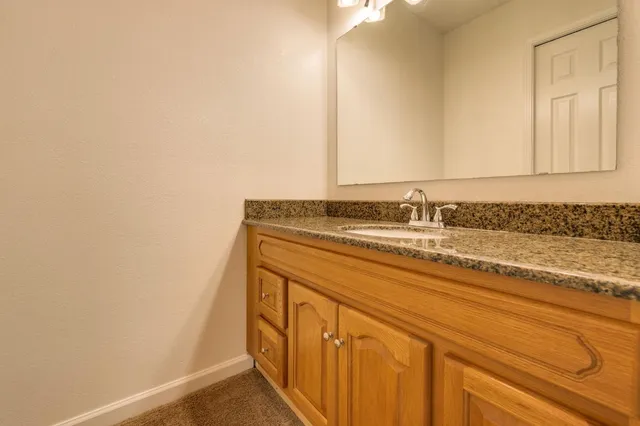 a bathroom with a granite countertop sink and a mirror