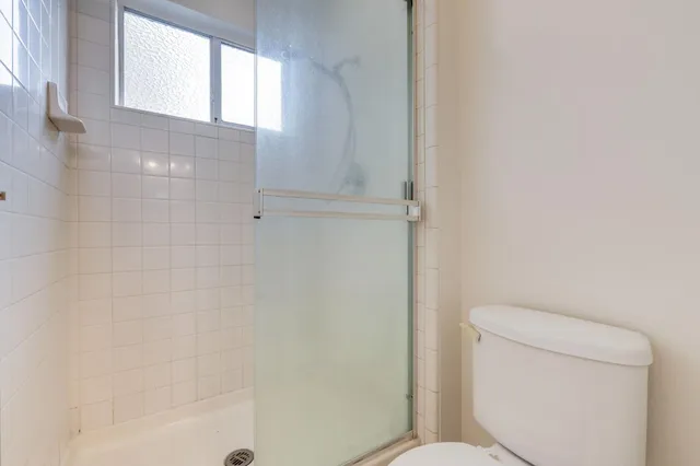 a bathroom with a toilet and a shower