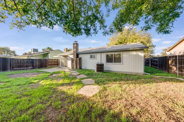 a view of a house with backyard and trees