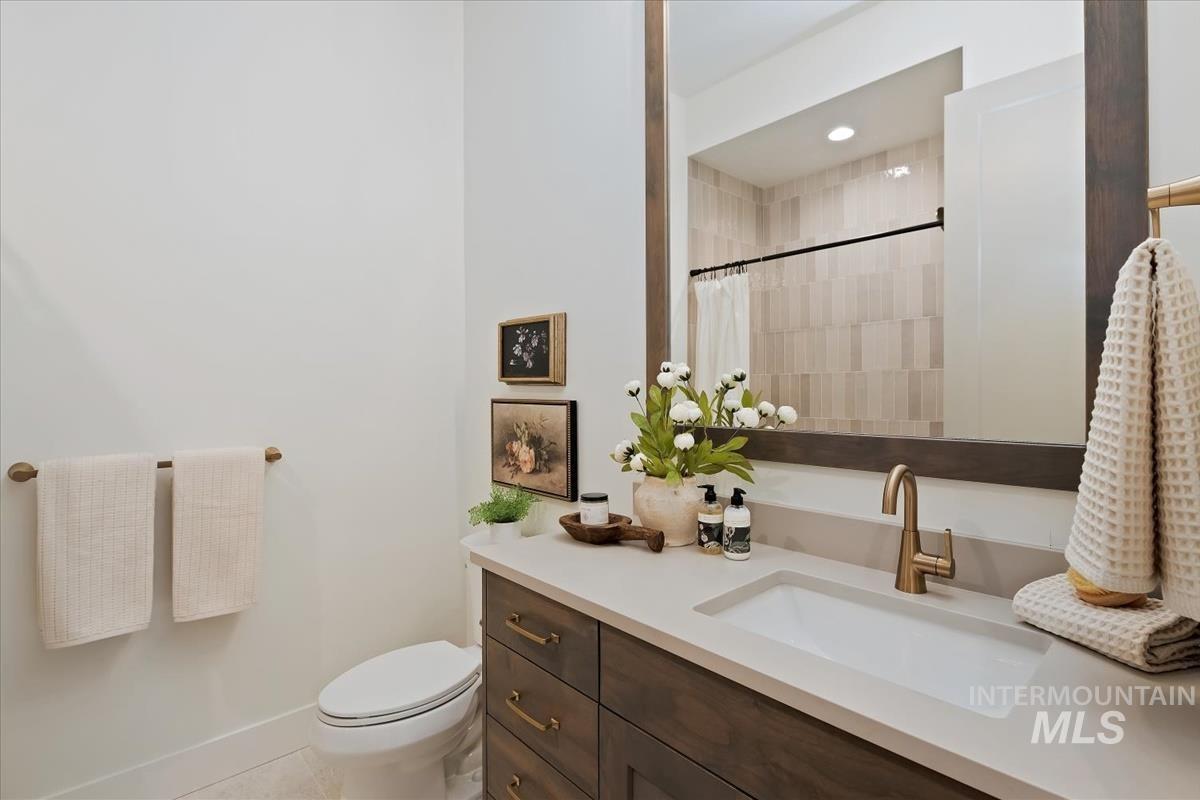 7615 Brown Way Eagle, ID 83714 - Photo 35 of 43 Bathroom featuring a wood-finish vanity with a light countertop, an undermount sink, and a bronze-finish faucet