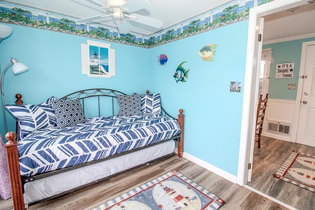 433 Lower County Road, Unit 25 Dennis, MA 02639 - Photo 16 of 32 a bedroom with a bed and wooden floor