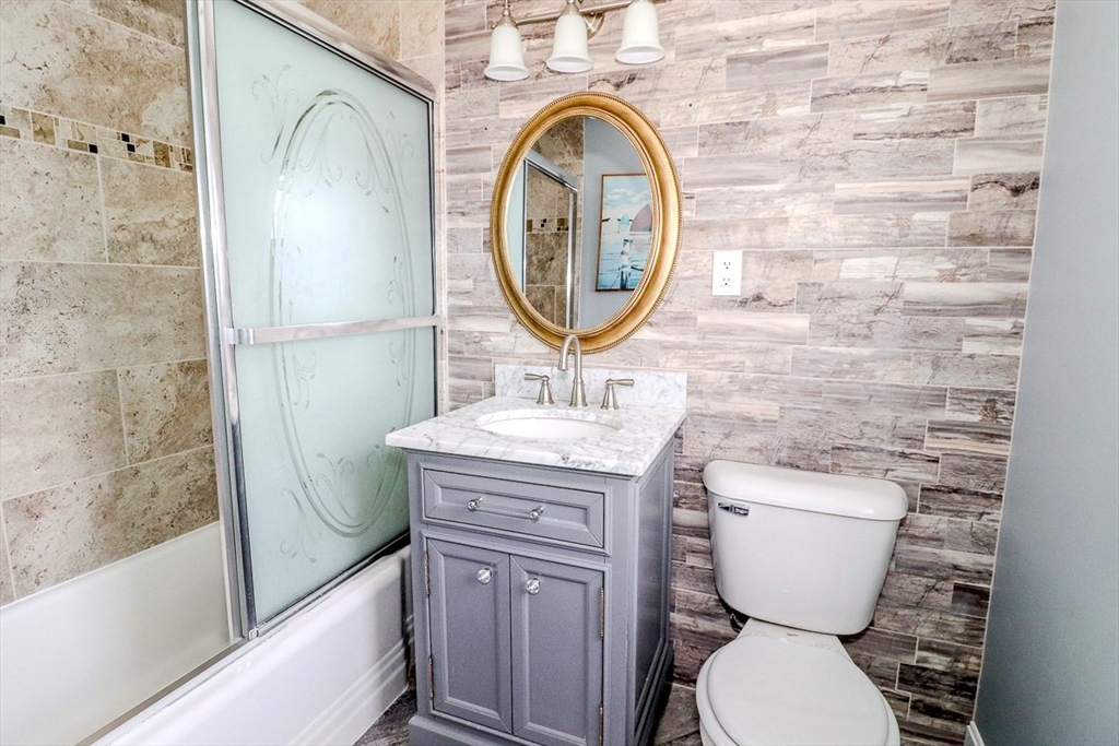 433 Lower County Road, Unit 25 Dennis, MA 02639 - Photo 19 of 32 a bathroom with a toilet a sink and a mirror
