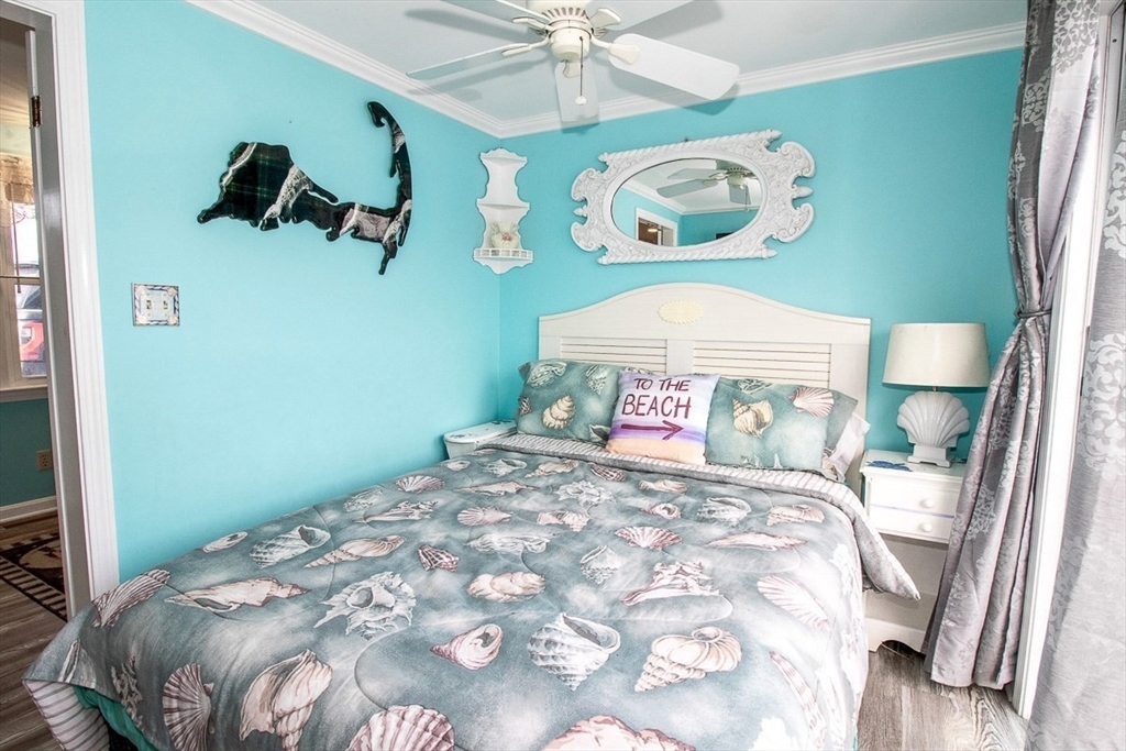 433 Lower County Road, Unit 25 Dennis, MA 02639 - Photo 2 of 32 a bedroom with a bed and a chandelier