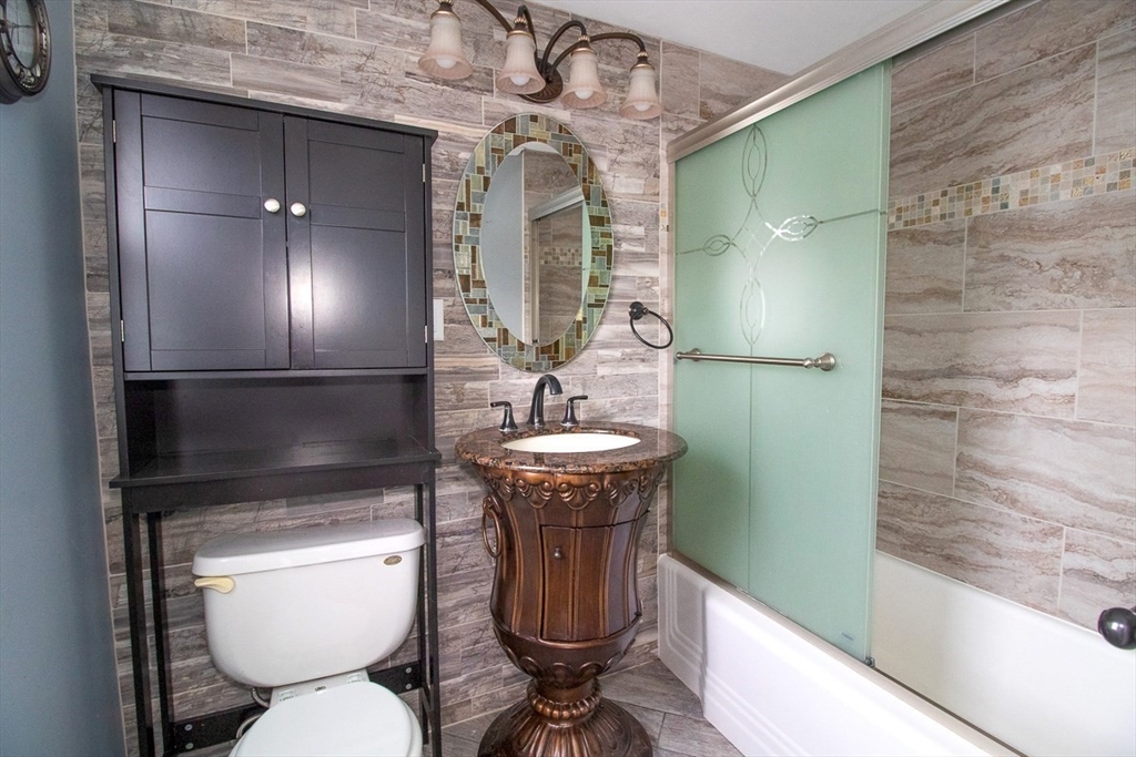 433 Lower County Road, Unit 25 Dennis, MA 02639 - Photo 4 of 32 a bathroom with a toilet a sink and mirror