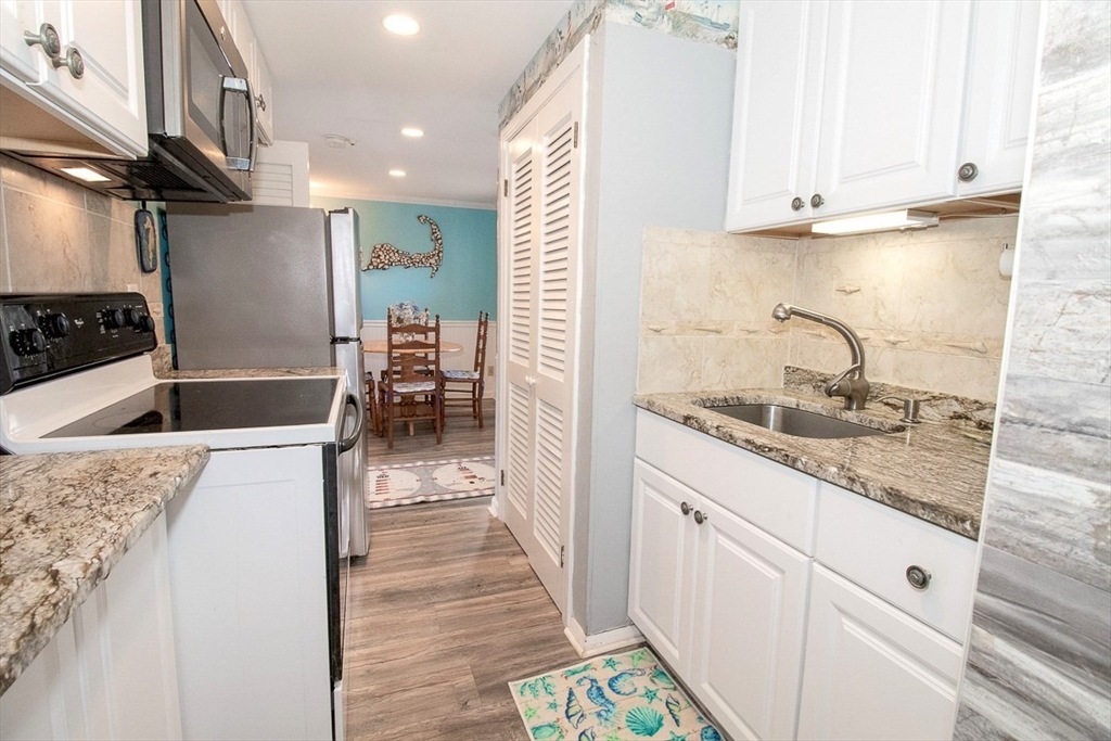 433 Lower County Road, Unit 25 Dennis, MA 02639 - Photo 8 of 32 a kitchen with granite countertop a sink and a stove