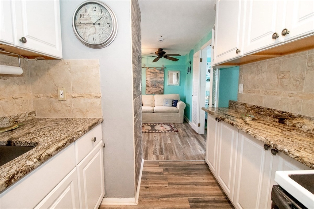 433 Lower County Road, Unit 25 Dennis, MA 02639 - Photo 9 of 32 a bathroom with a granite countertop sink and a stove