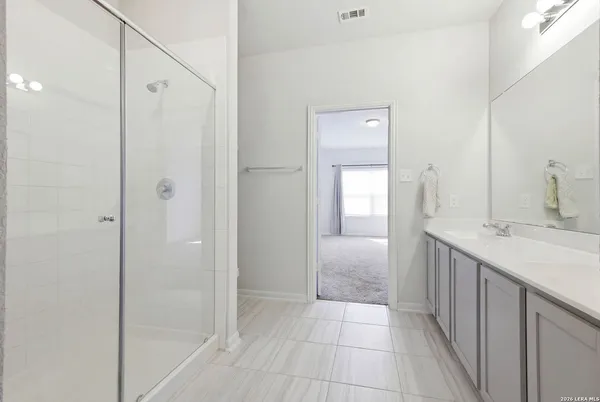 a bathroom with a granite countertop sink a mirror and a shower