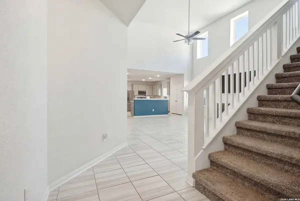 a view of staircase with white walls and fan