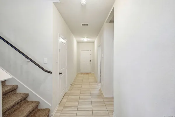 a view of a hallway with wooden floor and staircase