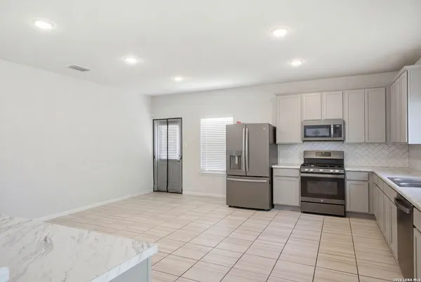 a kitchen with refrigerator and cabinets