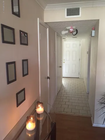 a view of a hallway with wooden floor and chandelier