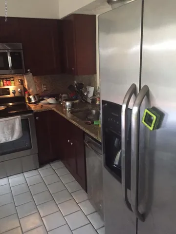 a kitchen with stainless steel appliances granite countertop a refrigerator and a sink