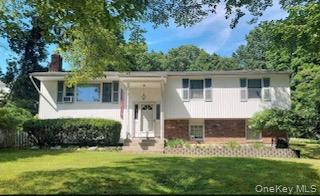 a view of a house with a yard and sitting area