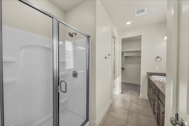 794 North Via Modelo Circle Washington, UT 84780 - Photo 19 of 21 Full bath with vanity, a walk in closet, a shower stall, light tile patterned flooring, and recessed lighting