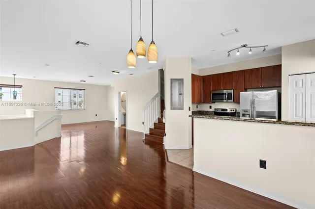 a view of a kitchen with microwave and wooden floor