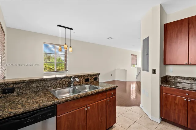 a kitchen with granite countertop a sink a counter space appliances and cabinets