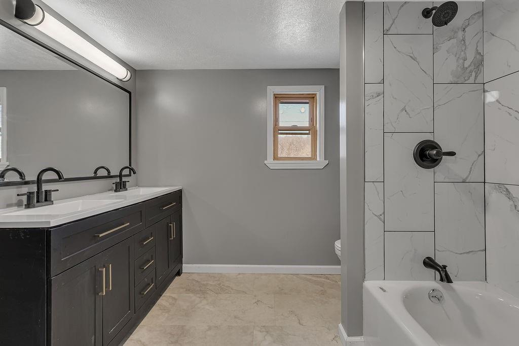 589 Pine Run Road Freedom, PA 15042 - Photo 23 of 29 a bathroom with a double vanity sink a mirror and a bathtub