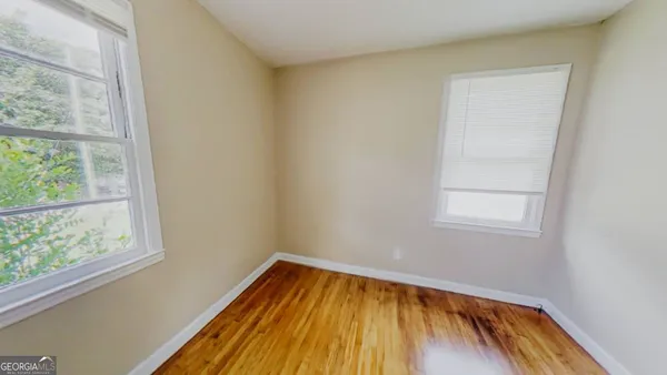 a view of a room with wooden floor and window