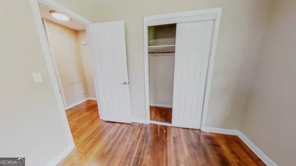 a view of empty room with wooden floor