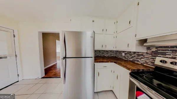 a kitchen with a refrigerator and a stove top oven
