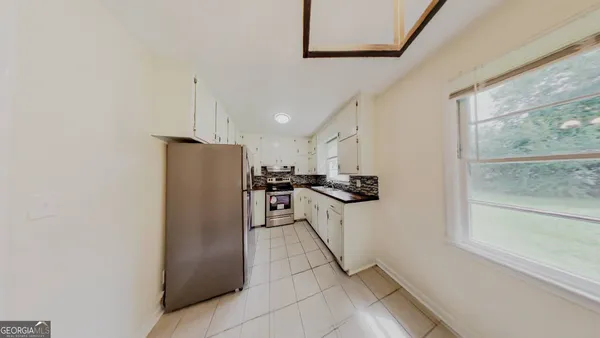 a kitchen with stainless steel appliances granite countertop a refrigerator and a sink