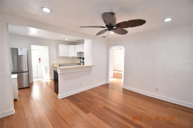a kitchen with a refrigerator and wooden floor