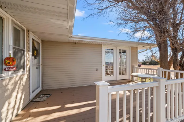 a view of a house with a small yard and wooden floor and fence