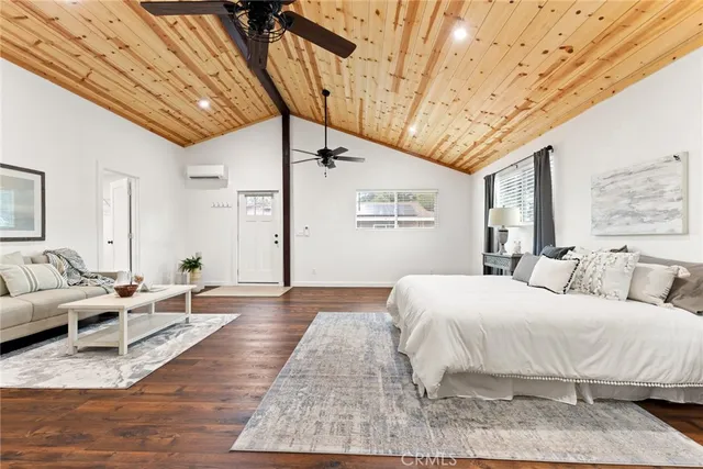a bedroom with a bed wooden floor and window