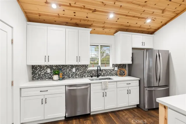 a kitchen with white cabinets and refrigerator