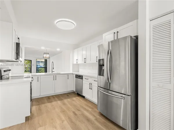 a kitchen with white cabinets and white stainless steel appliances