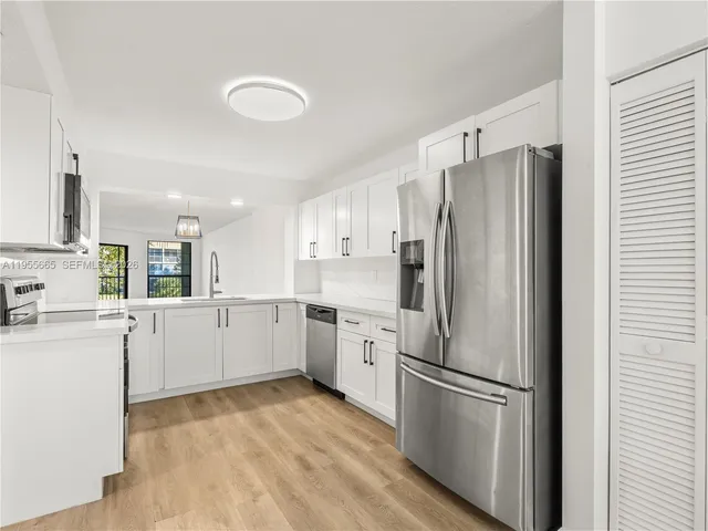 a kitchen with white cabinets and white stainless steel appliances