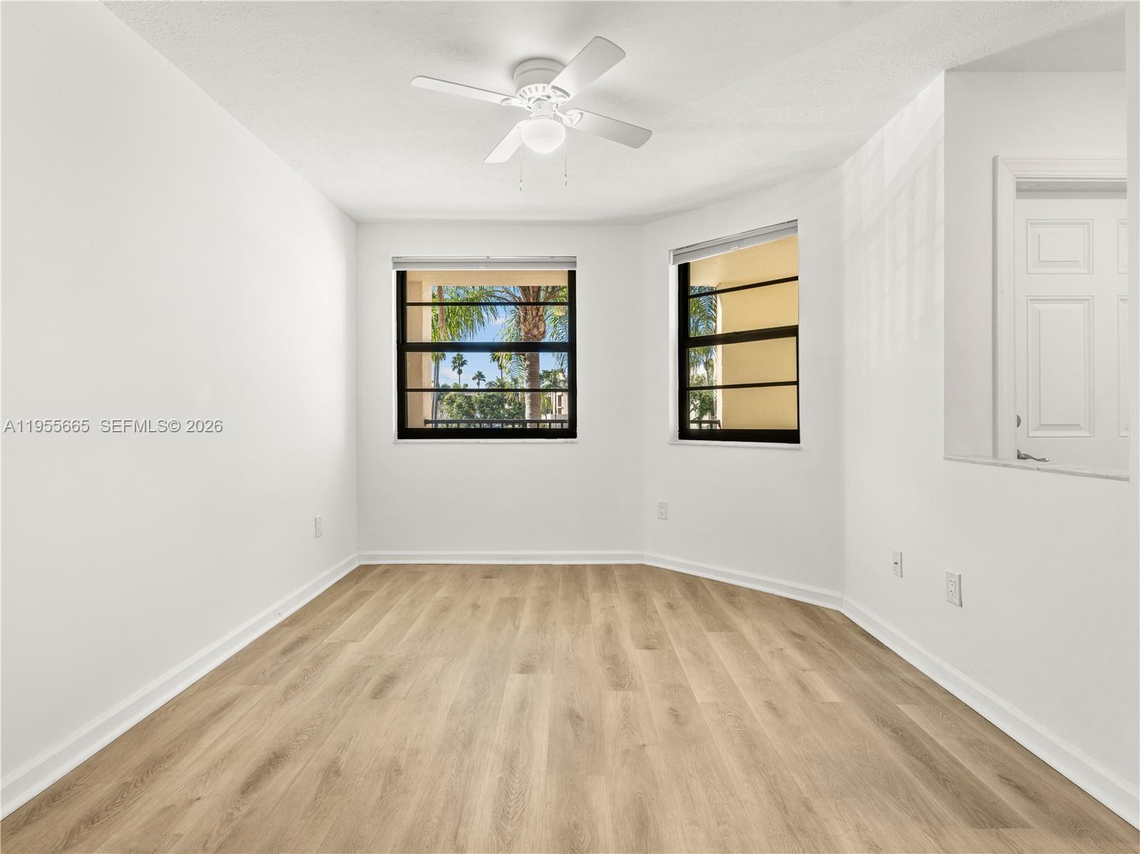 7547 Fairfax Drive, Unit 210 Tamarac, FL 33321 - Photo 14 of 38 an empty room with windows and ceiling fan